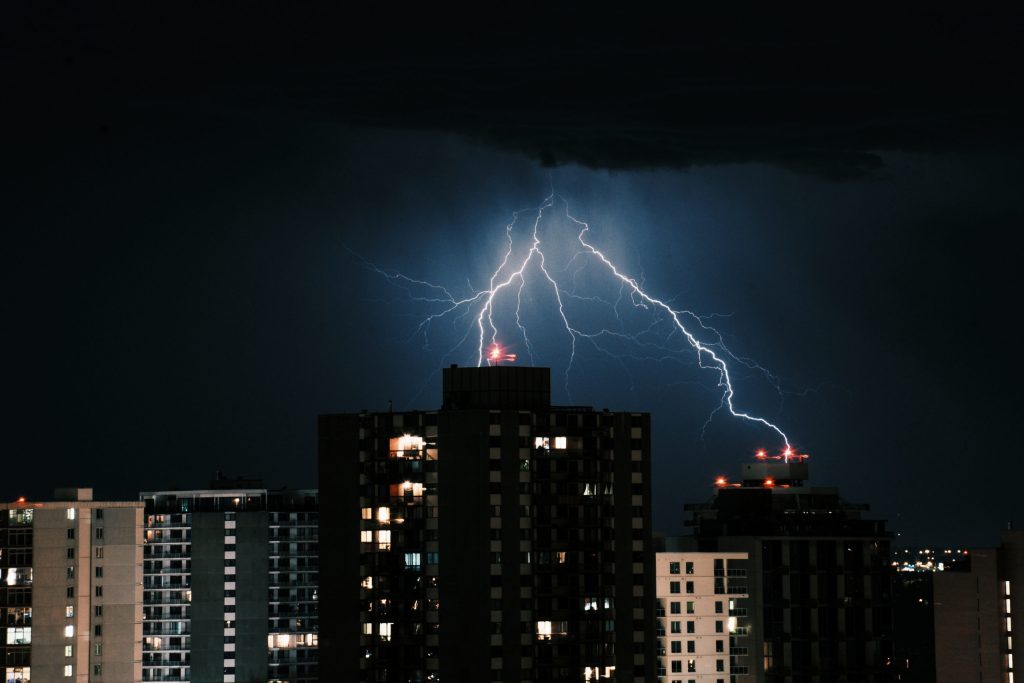 raios-no-ceu-escuro-sobre-os-edificios-da-cidade-a-noite-scaled