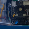 Técnico realizando manutenção preventiva em nobreak NHS com multímetro em bancada