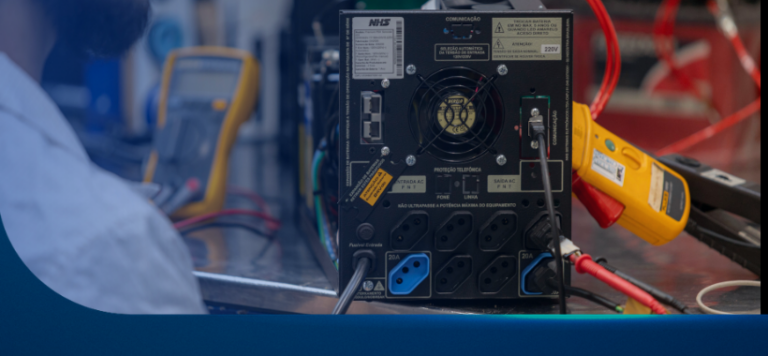 Técnico realizando manutenção preventiva em nobreak NHS com multímetro em bancada